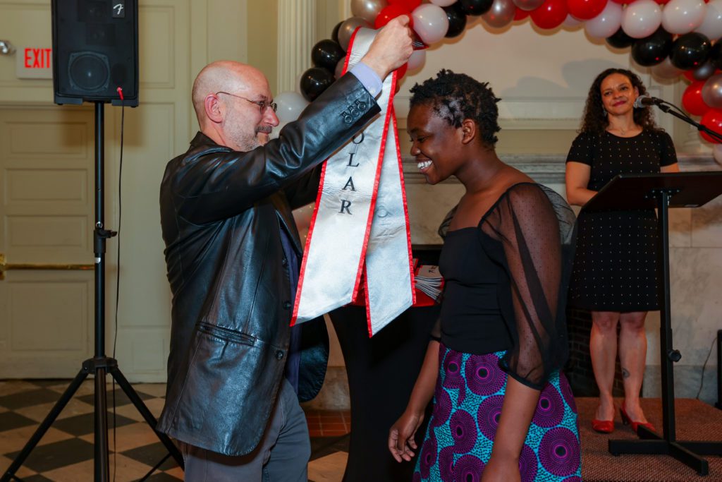 Jeff Tecosky-Feldman gives Pelagia Majoni her Chesick Scholar sash