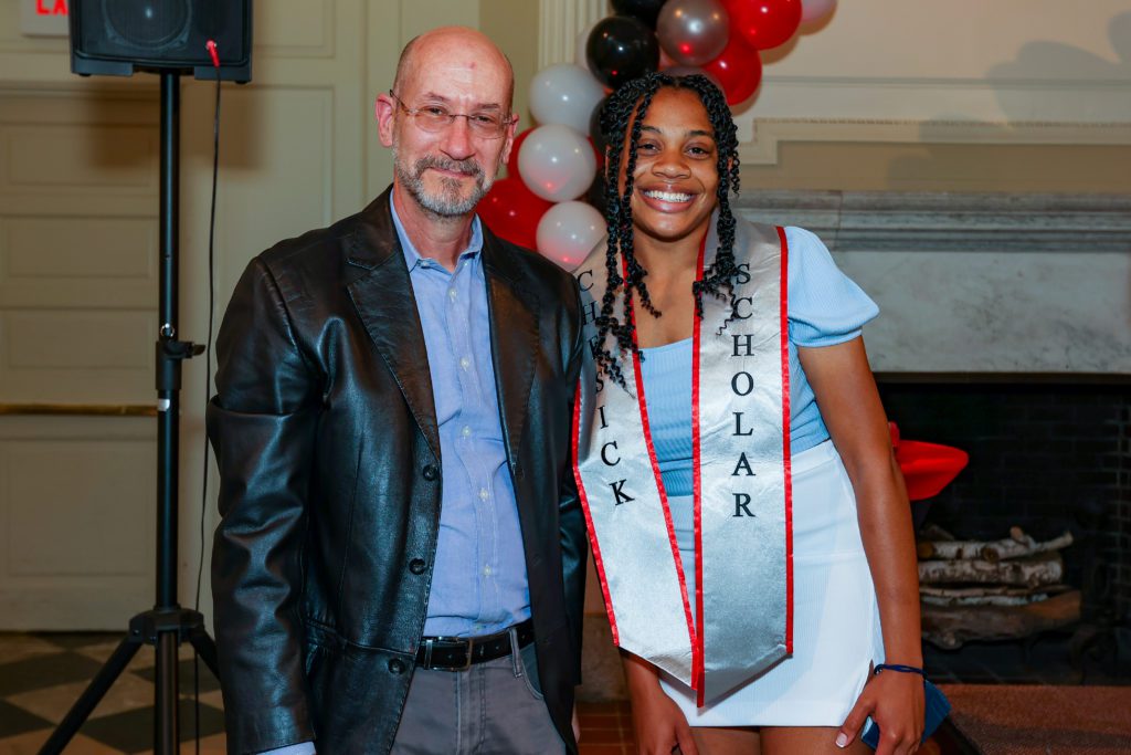 Zakiyyah Winston poses with Jeff Tecosky-Feldman with a red, white, and black baloo arch in the background