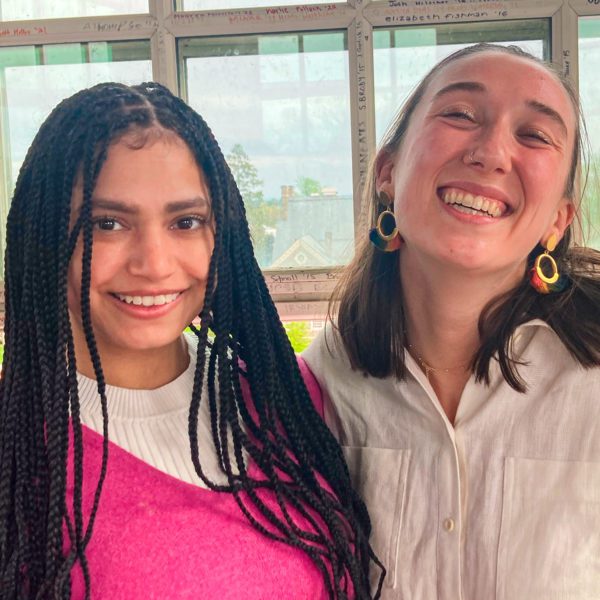 Zoe and Lizy are smiling next to a window