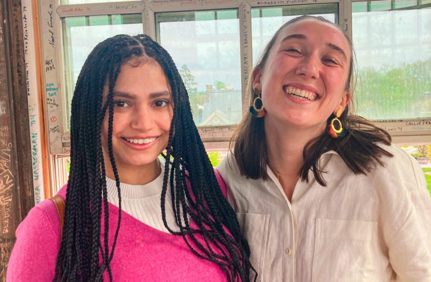 Zoe and Lizy are smiling next to a window