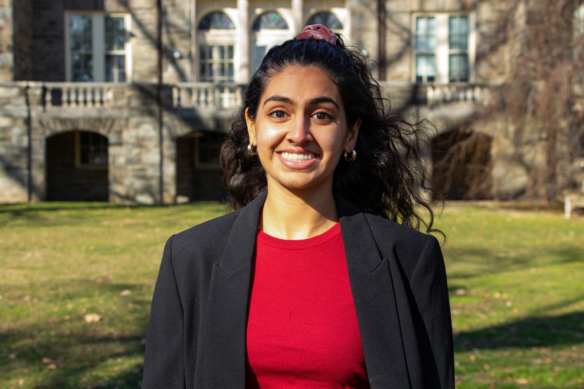 Shreya Singh '22 stands on Haverford's campus, smiling.