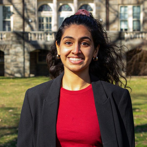 Shreya Singh '22 stands on Haverford's campus, smiling.