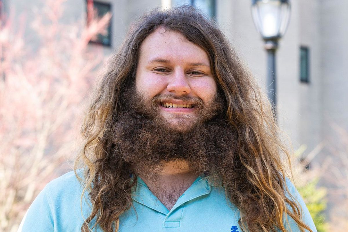 Trevor Stern '22 smiles in front of a background of trees.