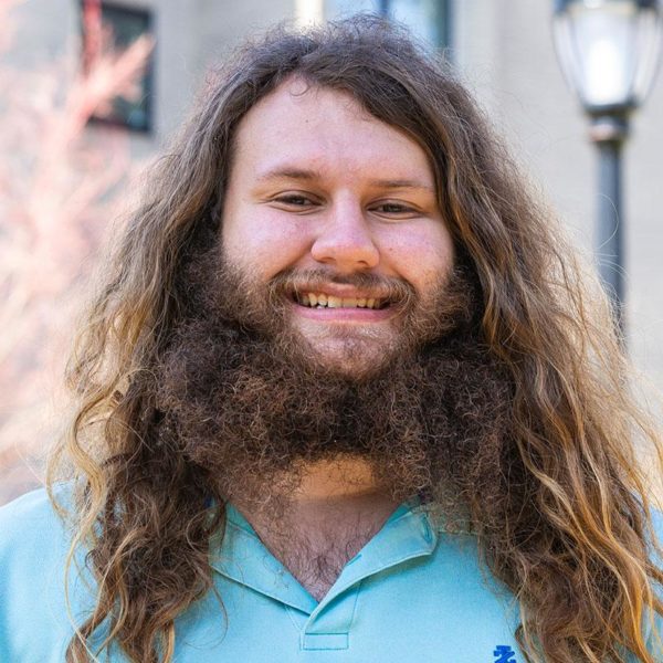 Trevor Stern '22 smiles in front of a background of trees.