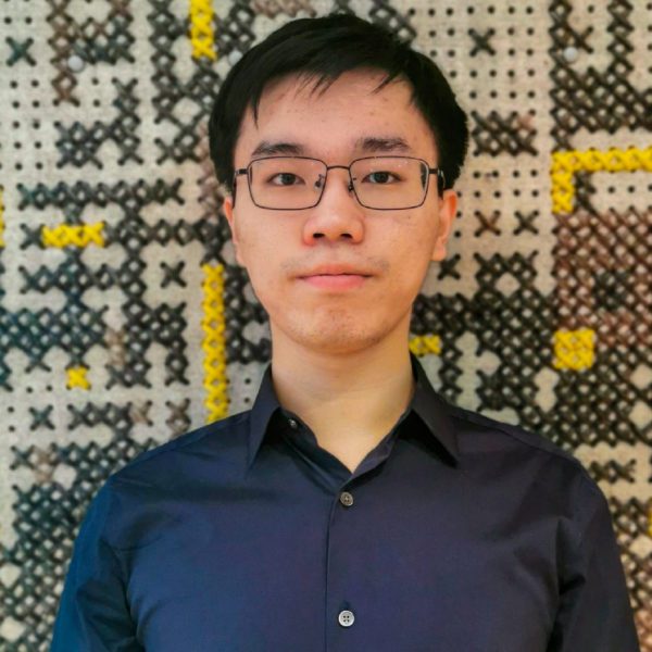 Qilong (Matthew) Chen '22 stands in front of a multicolored wall.