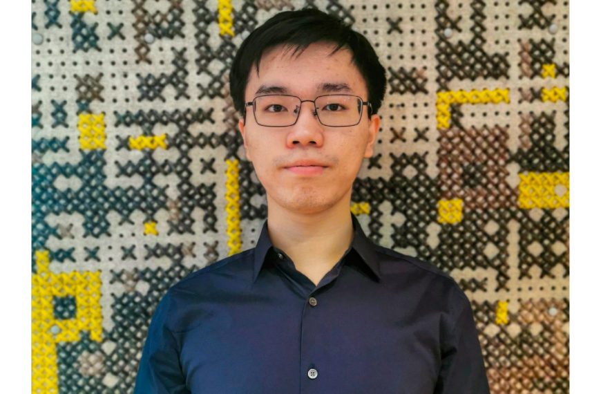 Qilong (Matthew) Chen '22 stands in front of a multicolored wall.
