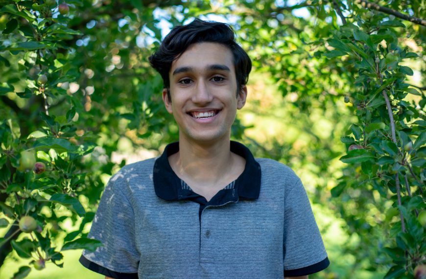 João smiles for the camera with trees in the background