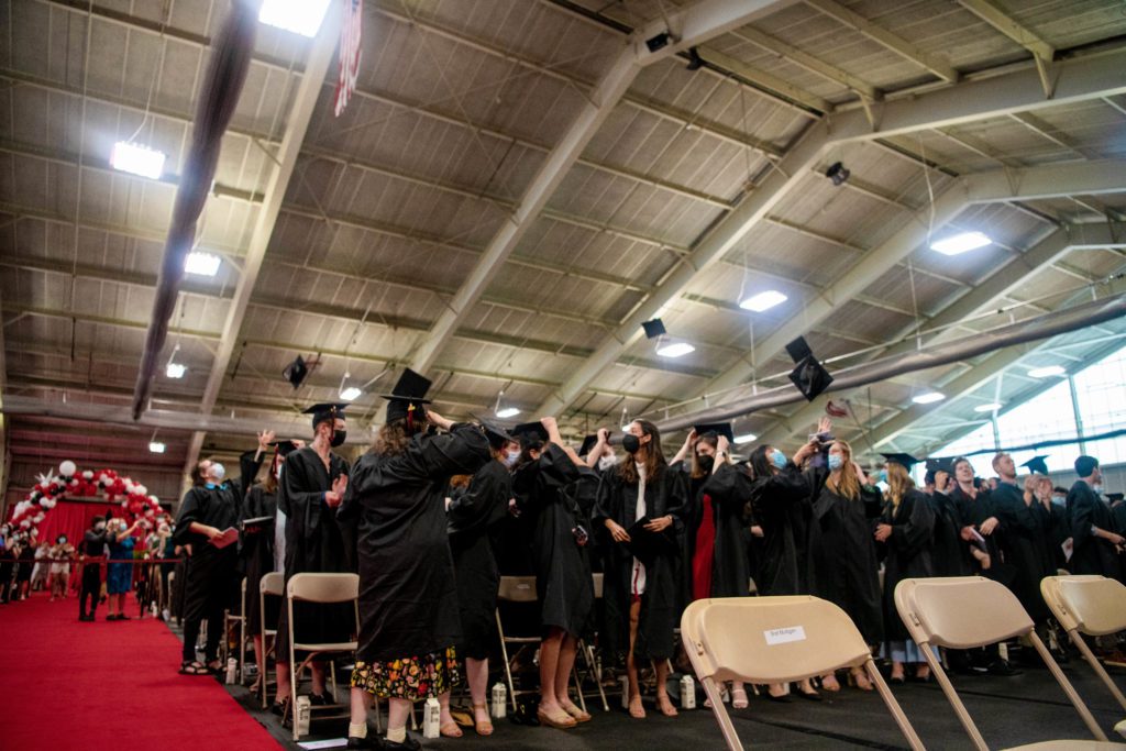 The Class of 2020 throws their graduation caps up to the ceiling in the Field House