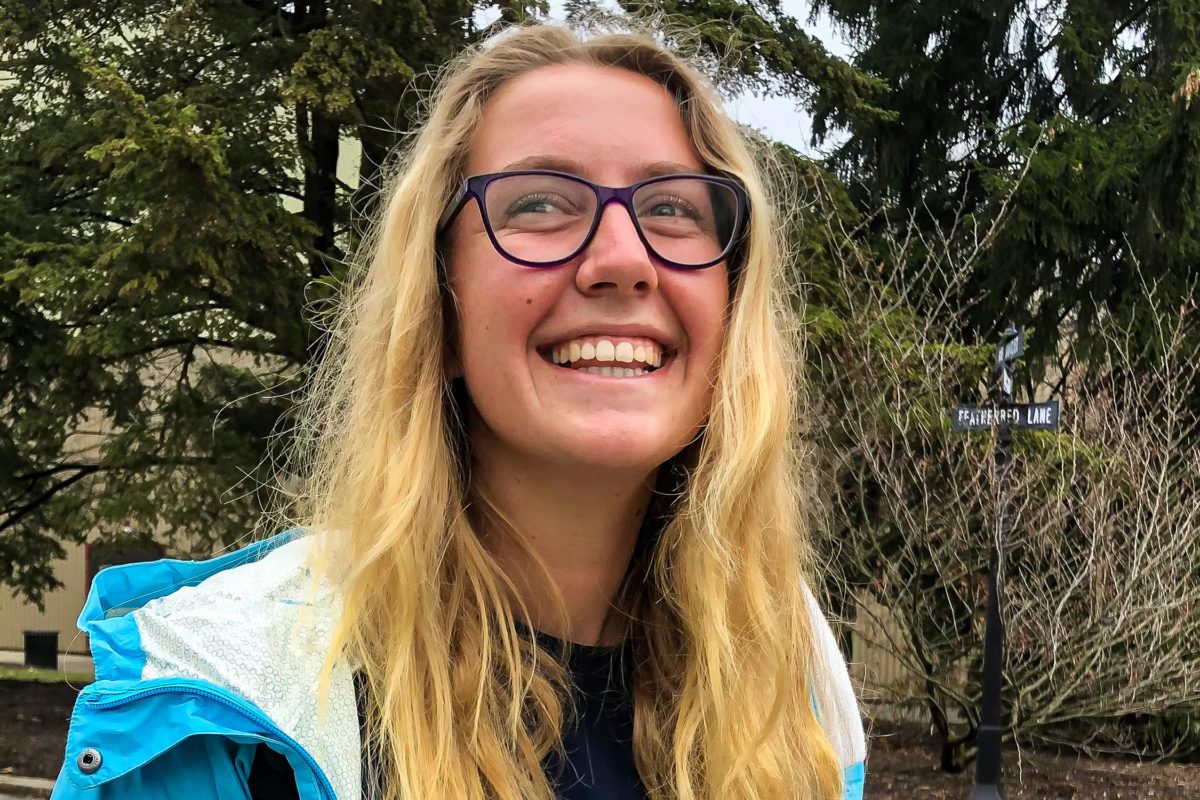 Riah Newfont '22 smiles in front of a tree.