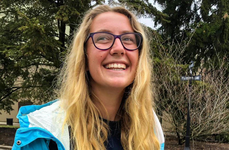 Riah Newfont '22 smiles in front of a tree.