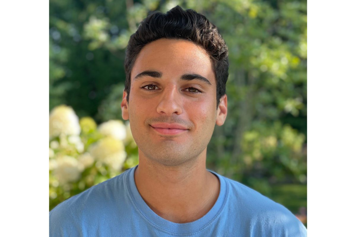Jackson Trevor '22 stands in front of a background of foliage.