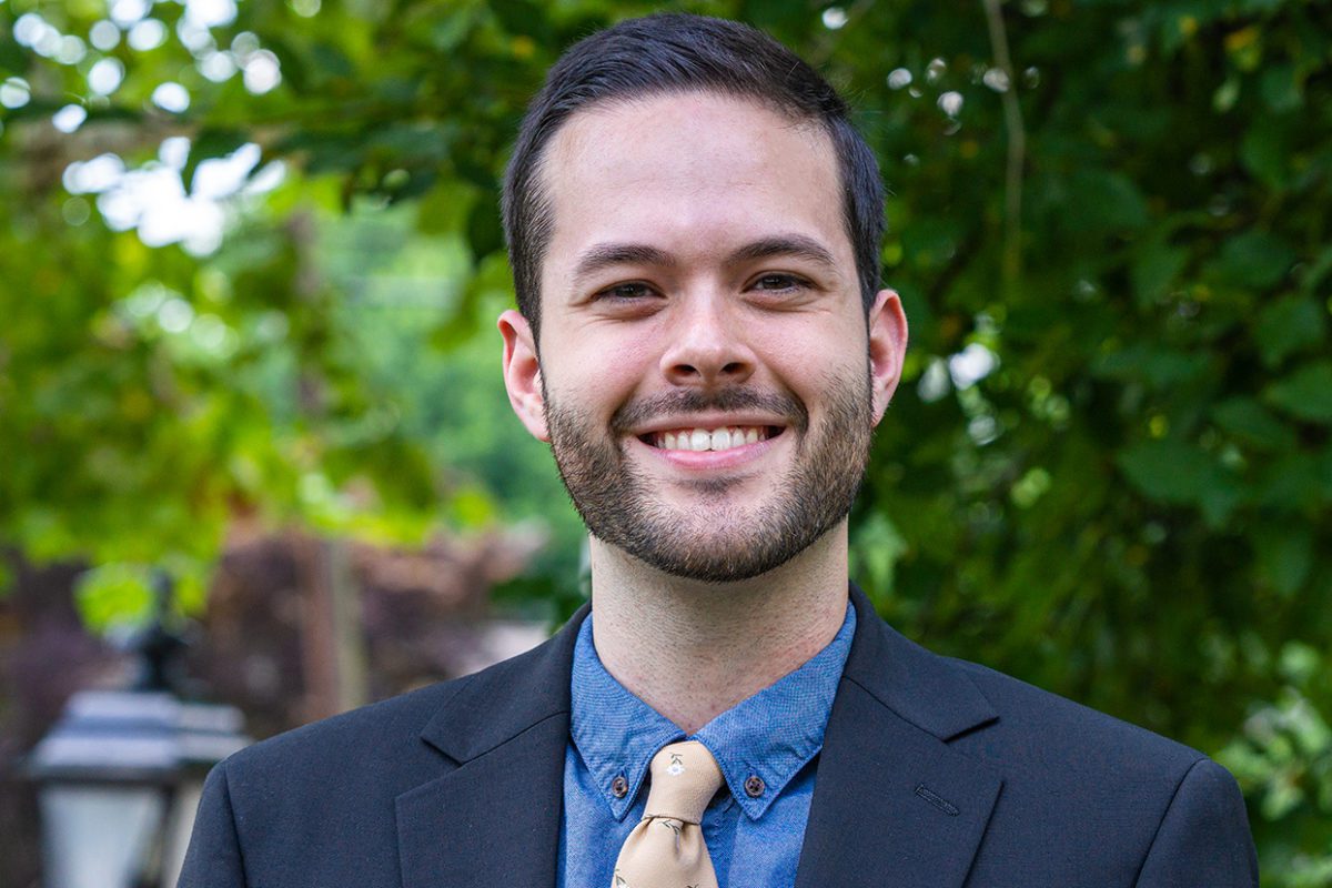 Ryan Totaro '22 stands in front of a background of trees. Photo by Patrick Montero.