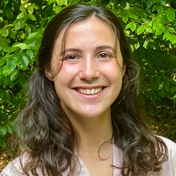 Callie Crawford '22 smiles in front of a background of trees.
