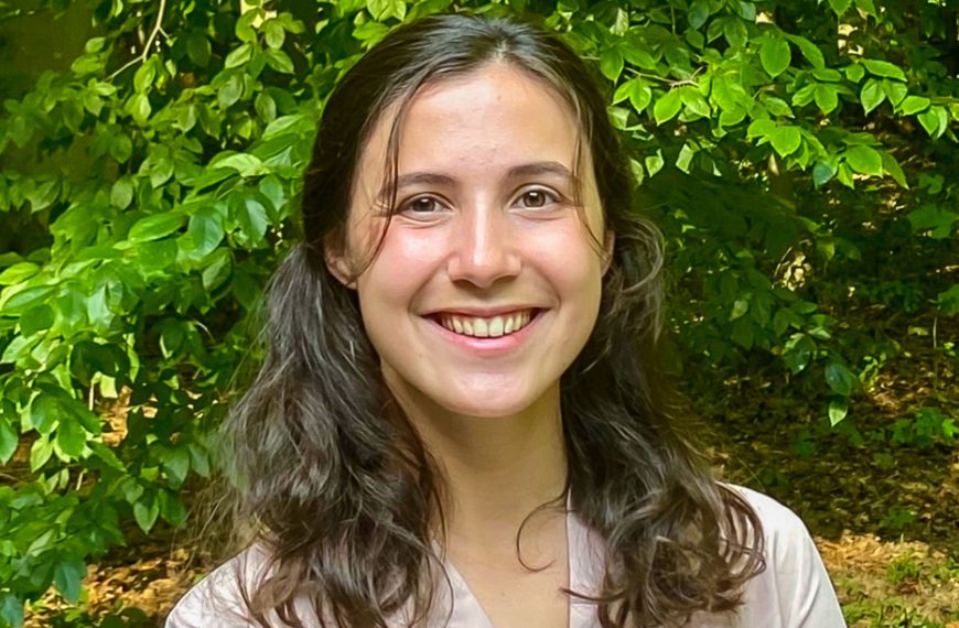 Callie Crawford '22 smiles in front of a background of trees.