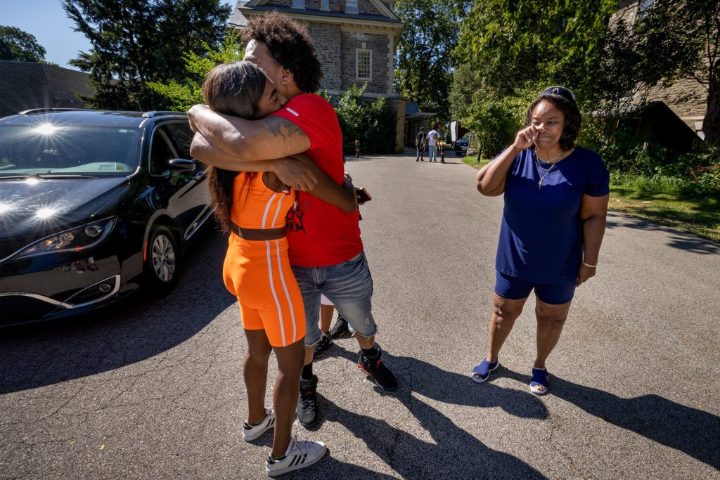 A mom wipes away a tear as her student gets a hug.