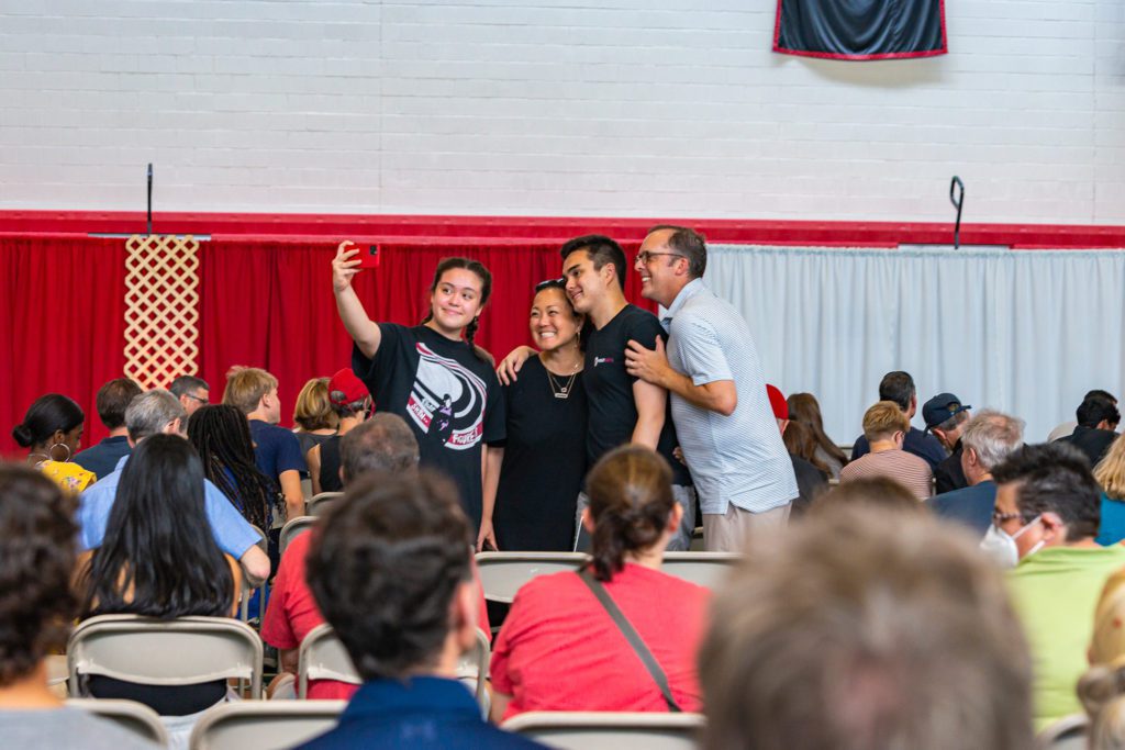 A family takes a selfie in the GIAC at the Welcome Ceremony.