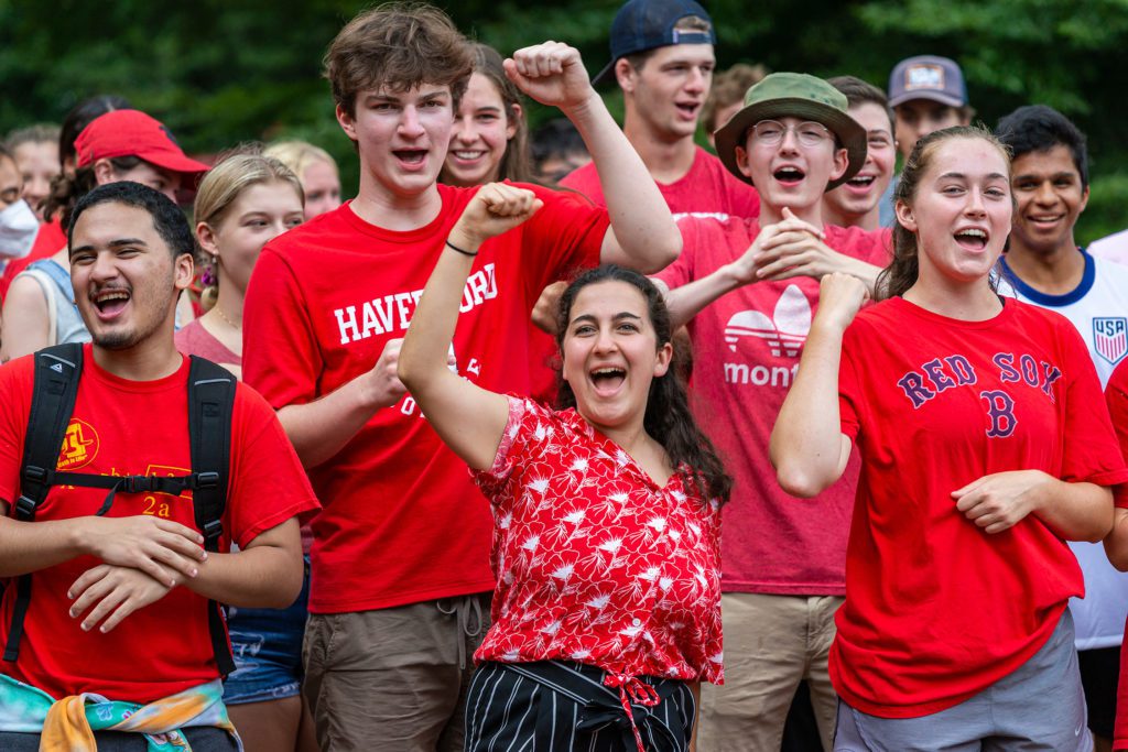 All dressed in red, students cheer with their fists in the air.