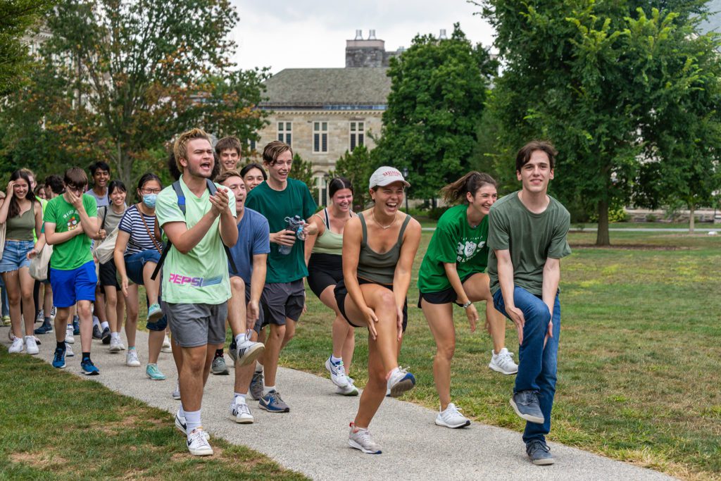 The Green Gummere team walks into Dorm Olympics holding one leg in the air.