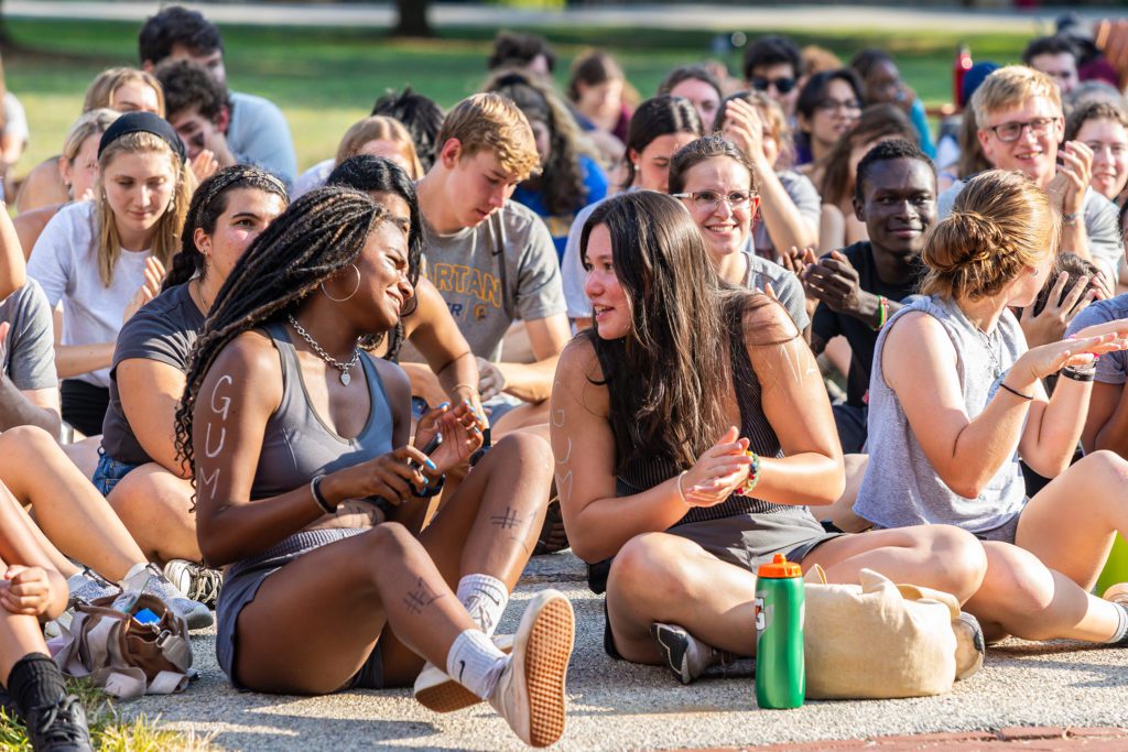 Two students on the gray Gummere team chat as the team sits on Founders Green.