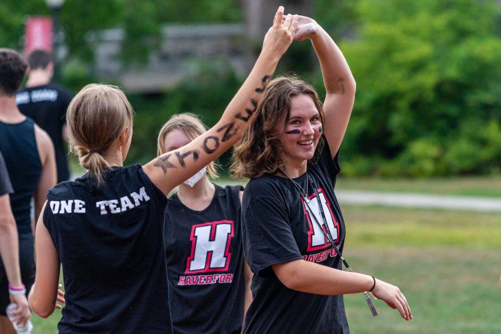 Two members of the black team dance, one of whom has written Jones down her arm