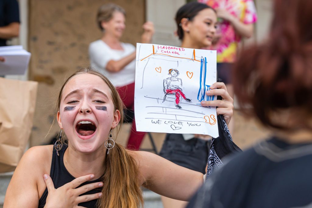 A student shares her drawing of President Raymond wearing red pants.