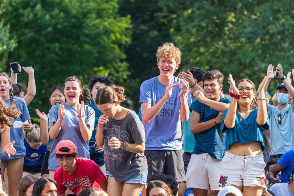 All dressed in blue, a group of students cheer.