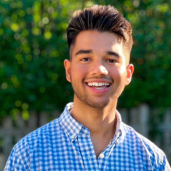 A headshot of John Jayasankar standing outside.