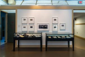 Photo of two display cases and one wall displaying David Freese's photographs and books.