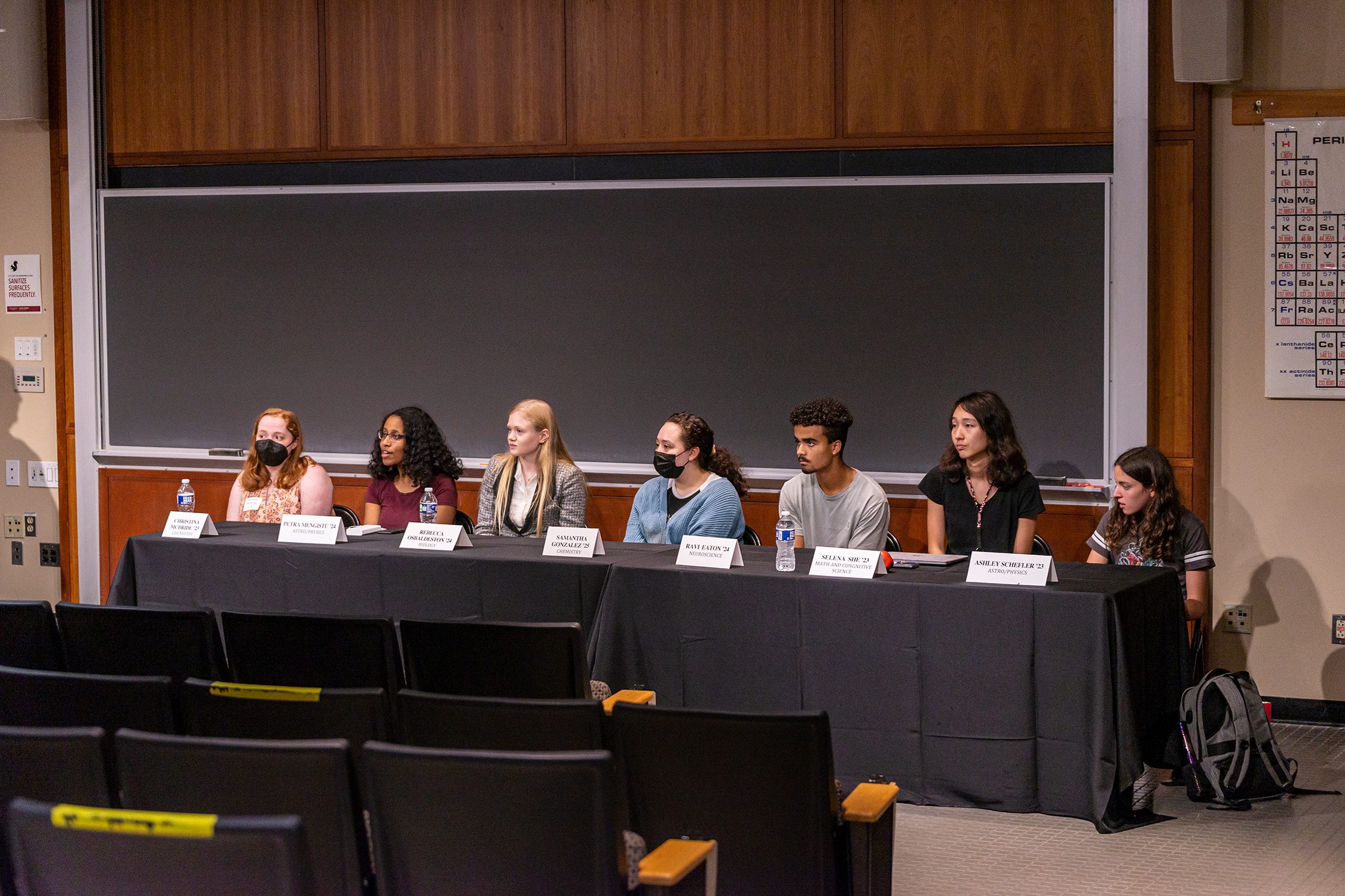 The panel of student researchers sits at the front of the auditorium, responding to an audience question. Photo by Patrick Montero.