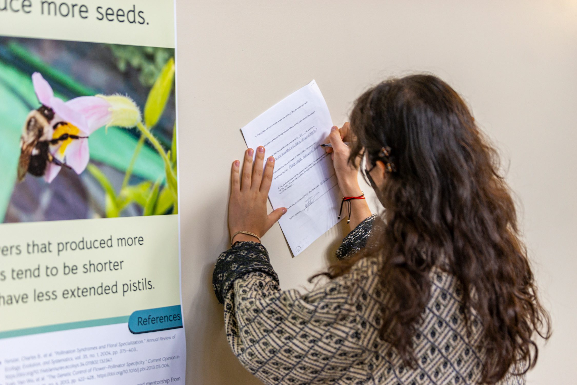 A student works on a poster scavenger hunt activity at the Undergraduate Science Research Symposium. Photo by Patrick Montero.