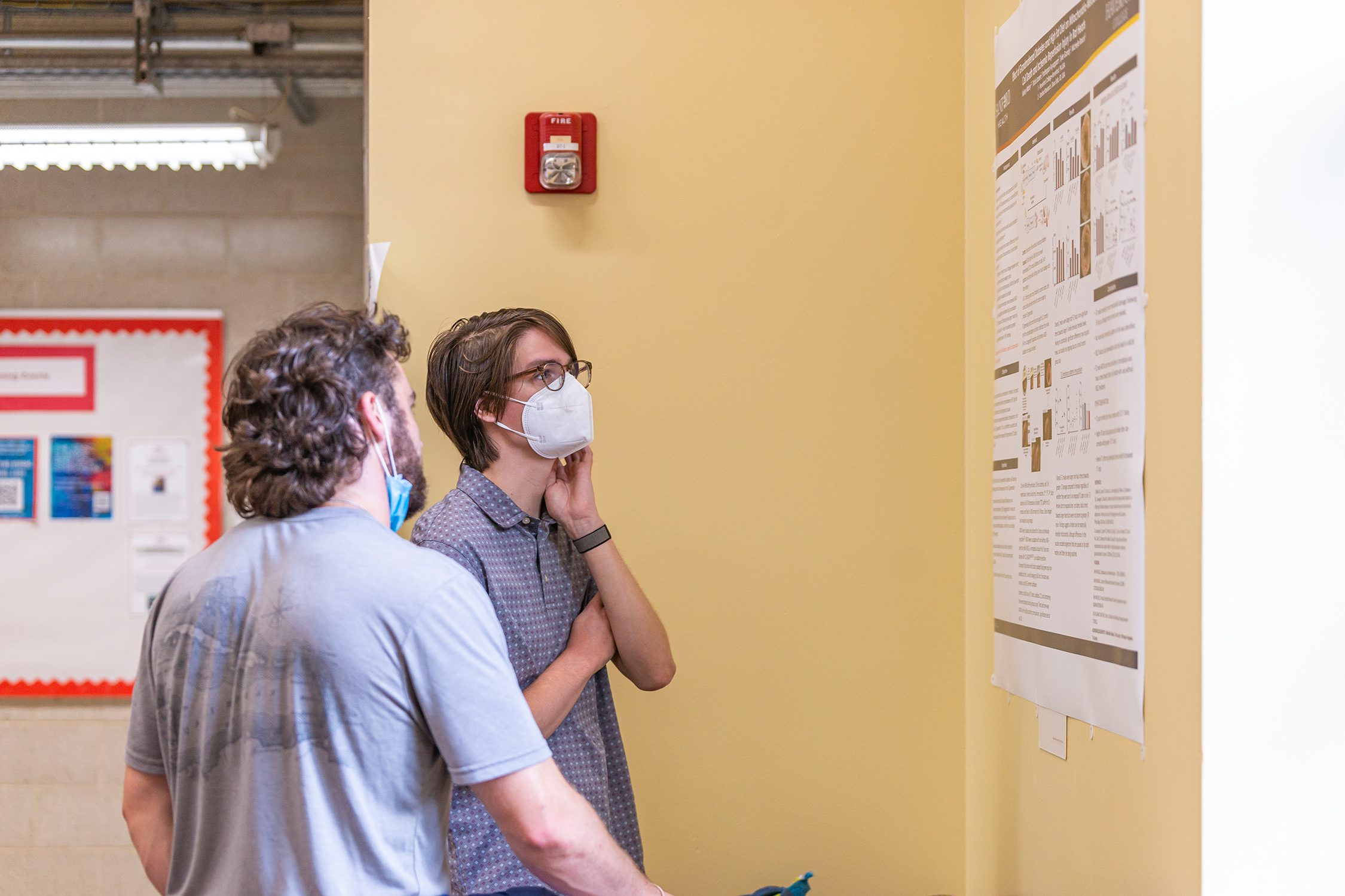 Attendees examine a poster at the Undergraduate Science Research Symposium. Photo by Patrick Montero.