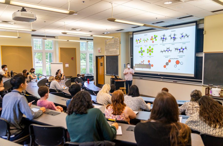 Logan Smith '23 presents his research in front of a large lecture hall of listeners. Photo by Patrick Montero.