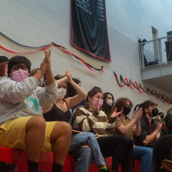 Students sitting in the bleachers applaud during plenary. Photo by Logan de Raspide Ross '23.