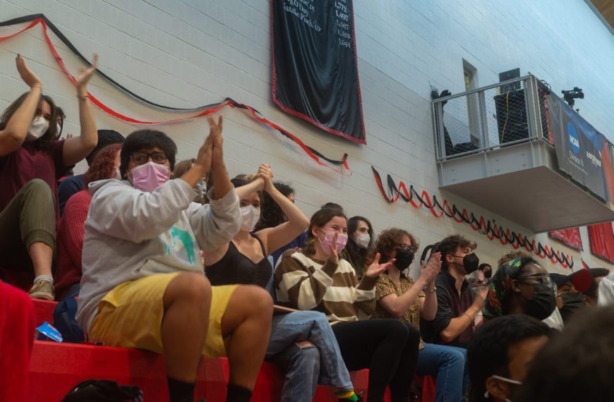 Students sitting in the bleachers applaud during plenary. Photo by Logan de Raspide Ross '23.