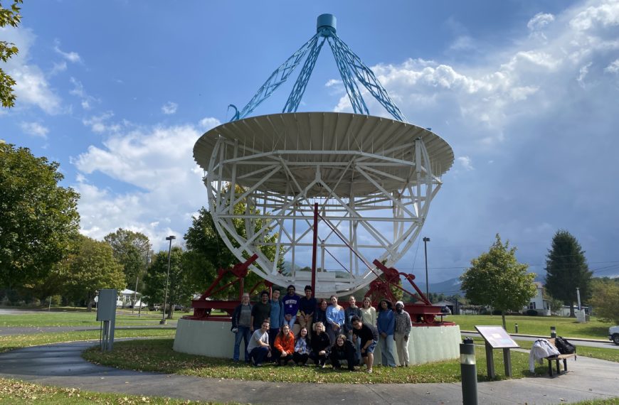 16 students in the astronomy class pose with Professor Masters in front of the Grote Reber dish at the Green Bank Observatory.