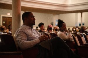 Dean John McKnight attentively watching Imani Perry.