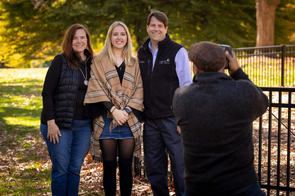A fall family portrait outside surrounded by leaves