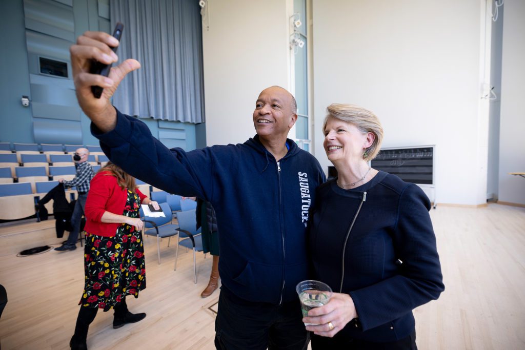Inside the concert hall a man poses for a photo with the College president.