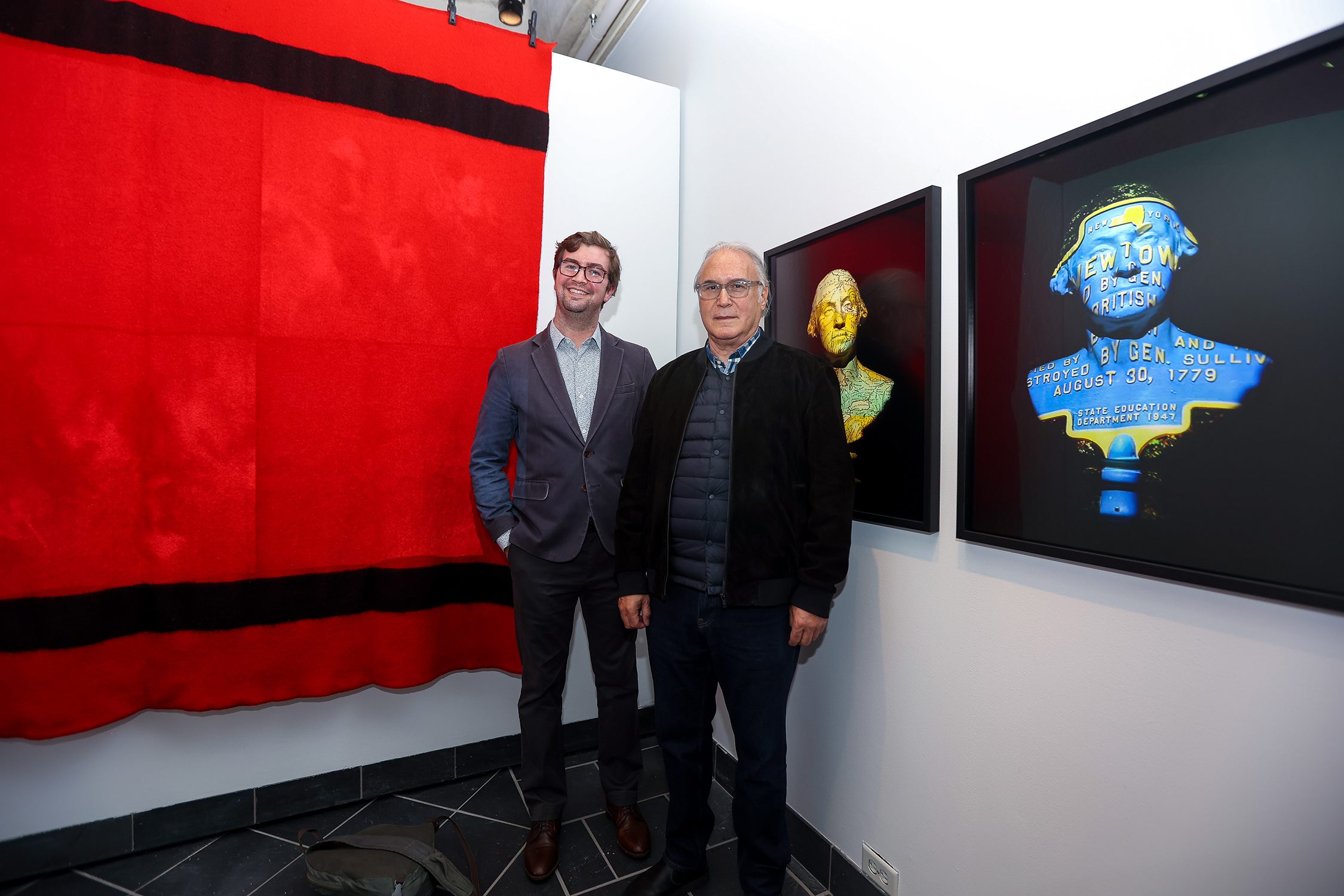 Christopher Green and Alan Michelson stand and smile together in front an exhibit in "Native America: In Translation." Photo by Paola Nogueras.