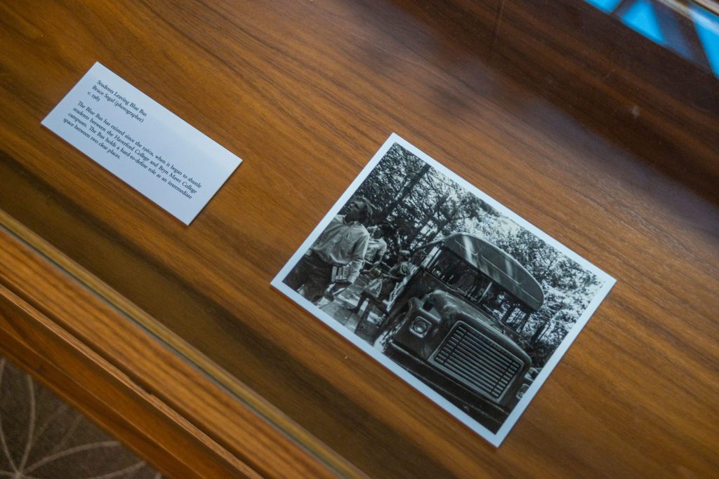 A photo of students leaving the blue bus from 1983 on display in the exhibit. Photo by Patrick Montero. Original photo by Bruce Segal.