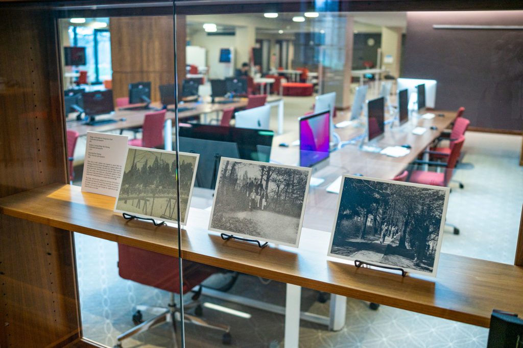 Three photos on display in "The Spaces Between" lie behind a glass covering. Photo by Patrick Montero.