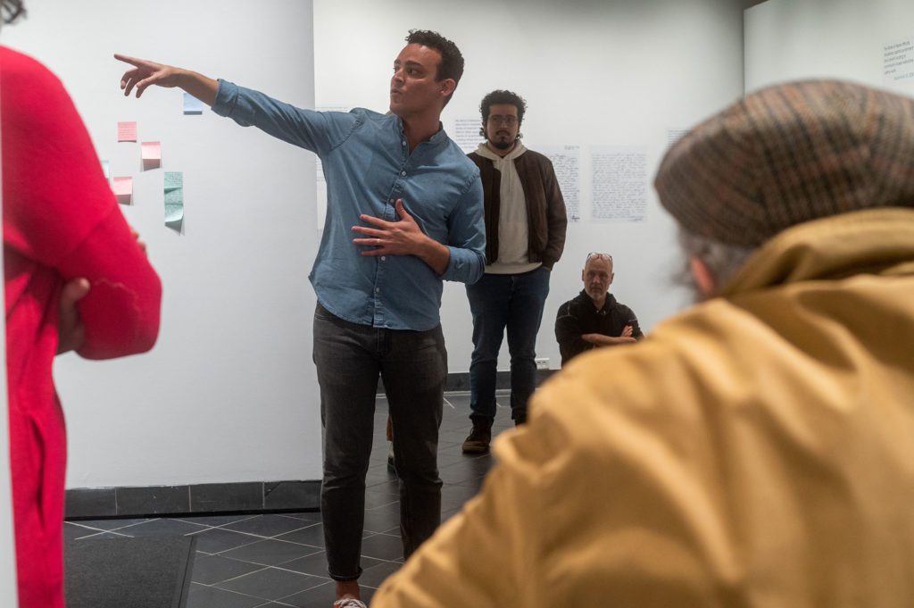 Artist Mark Menjívar speaking inside the gallery at the exhibition opening. Photo by Logan de Raspide Ross '23.
