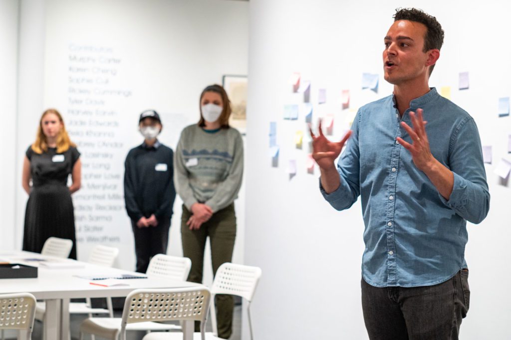 Artist Mark Menjívar speaking inside the gallery at the exhibition opening. Photo by Logan de Raspide Ross '23.