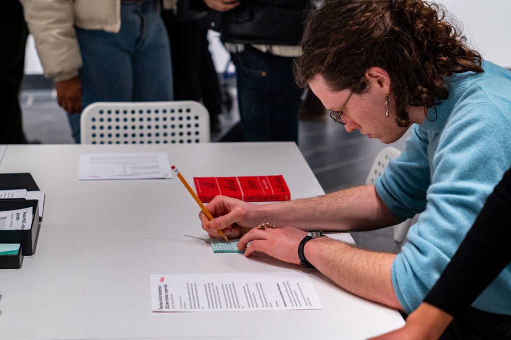 Attendee writing thoughts on a post-it note. Photo by Logan de Raspide Ross '23.