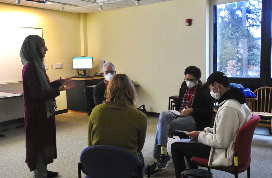 Participants sit in a semi-circle at a breakout session and listen to a presenter. Photo by Abigail Trapp '26.