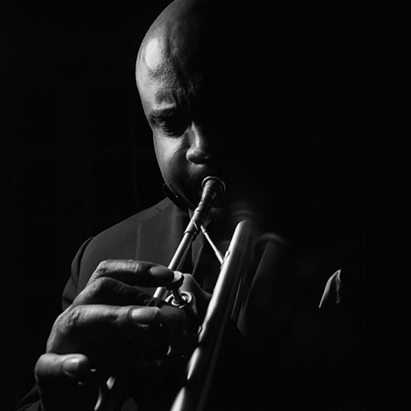 Terell Stafford plays the trumpet in front of a black background.