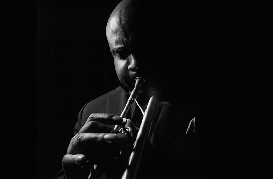 Terell Stafford plays the trumpet in front of a black background.