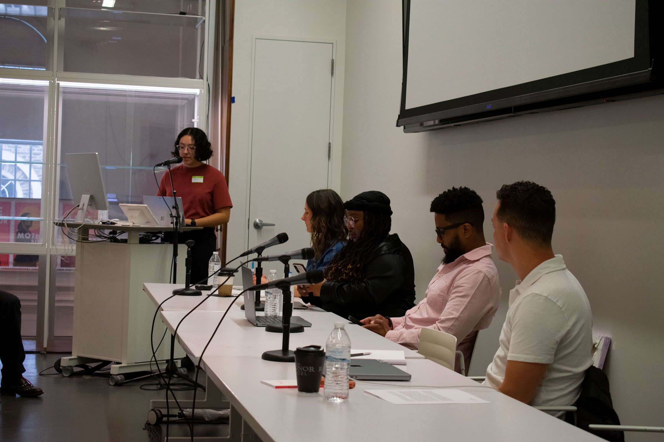 Panelists sit in a row and discuss community engagement, art, and music at the front of a room. Photo by Sumita Lacey '26.