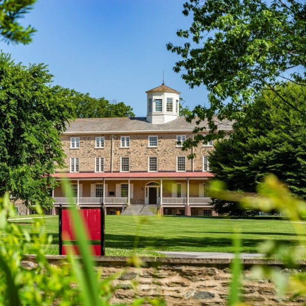 View of Founder's Hall on a nice day through the greenery