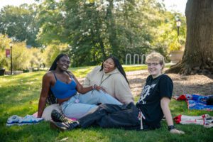 Three students sitting under a tree on campus_photo by Holden Blanco '17